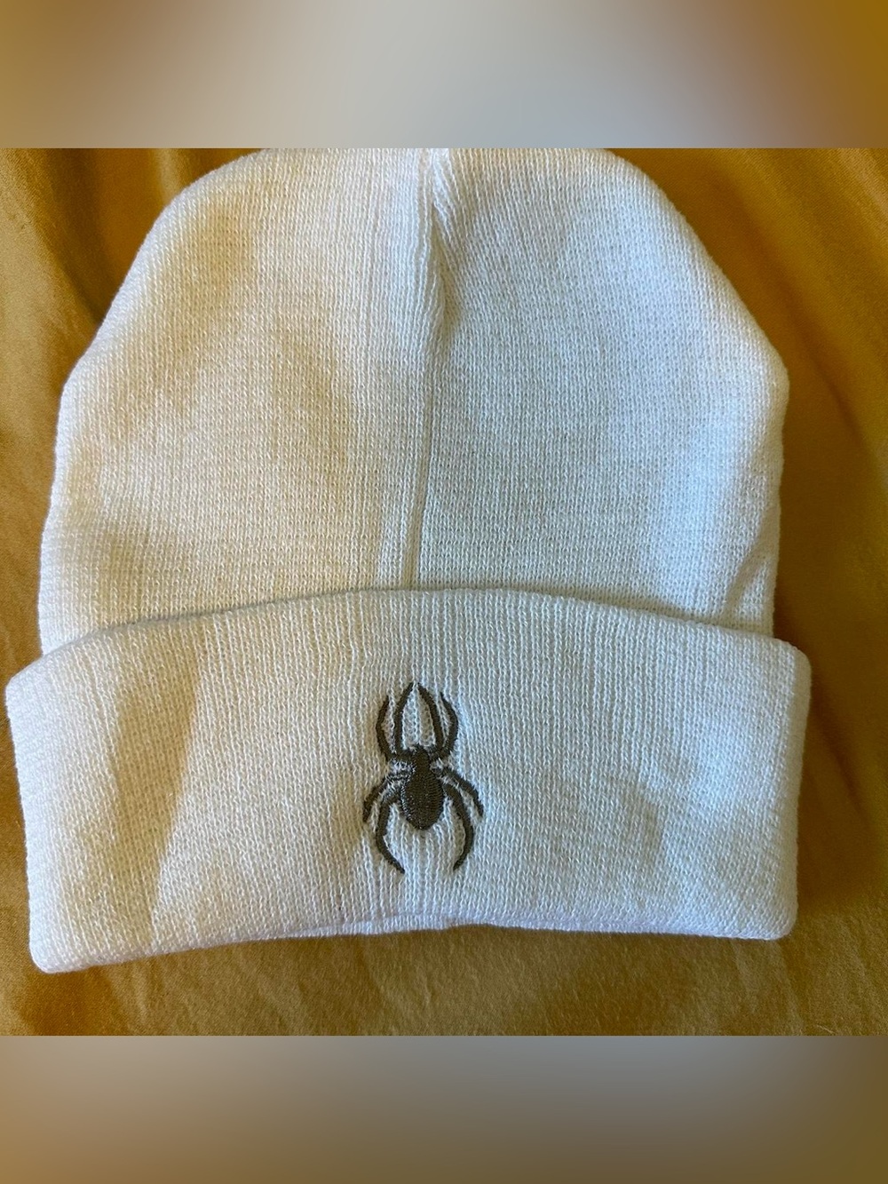 White and gray embroidered spider man beanie.